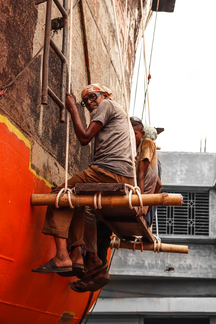 Workers engaged in facade repairs, suspended on ropes outdoors.